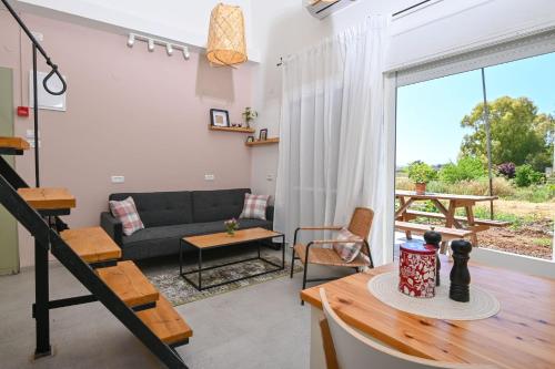 a living room with a couch and a table at YalaRent Valley view Boutique cottages with Pool in Merhavyāh