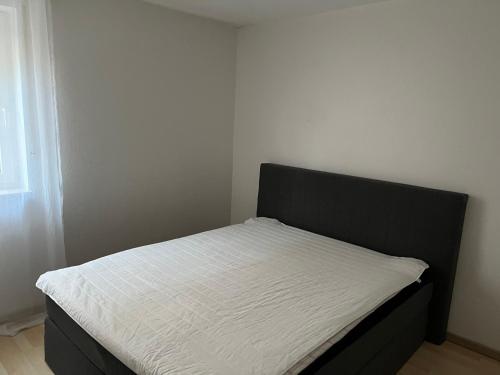 a bed with a black headboard in a bedroom at Victoria Appartement in Kappel-Grafenhausen