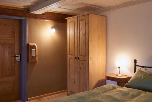 a bedroom with a bed and a wooden cabinet at Doppelzimmer Dora Oberlausitzer Hof in Leutersdorf