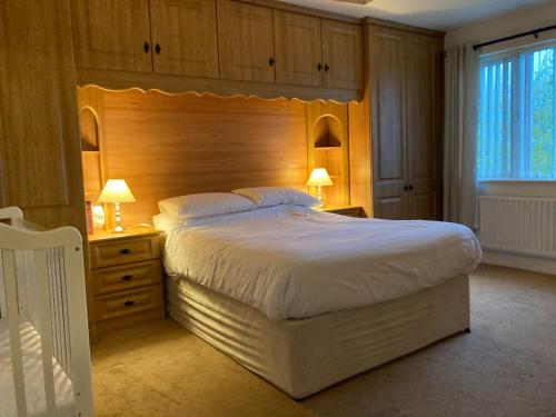 a bedroom with a large bed with a wooden headboard at Springfield Holiday Home in Carndonagh