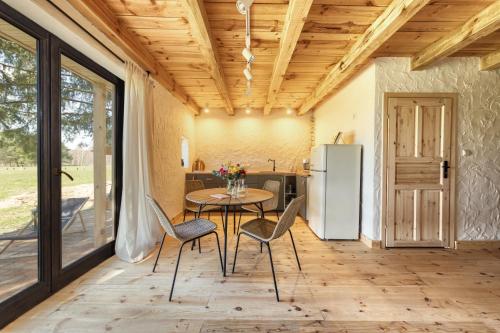 a kitchen with a table and chairs and a refrigerator at Prywatna Wieś in Mörken