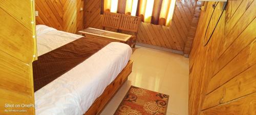 a small bedroom with a bed and a wooden door at Hotel Himalayan Galaxy in Chakrāta