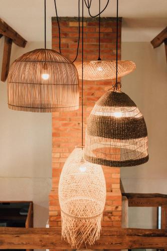 three lights hanging from a ceiling with some nets at Prywatna Wieś in Mörken