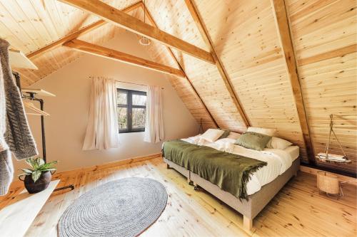 a bedroom with a bed in a room with wooden ceilings at Prywatna Wieś in Mörken