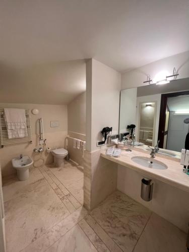 a large bathroom with two sinks and a toilet at Ruzzini Palace Hotel in Venice