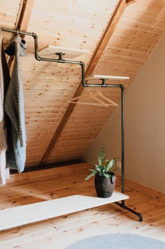 a room with a wooden ceiling with a plant on a shelf at Prywatna Wieś in Mörken