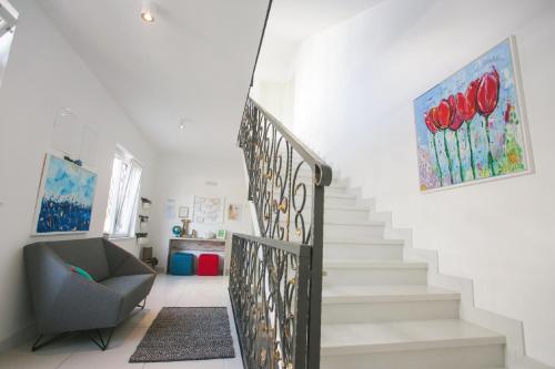 a staircase in a home with a chair and a painting at Apartments Villa Lukas in Cavtat