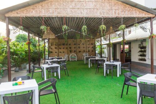 a restaurant with tables and chairs on the grass at Hotel The Enchanted in Dhaka
