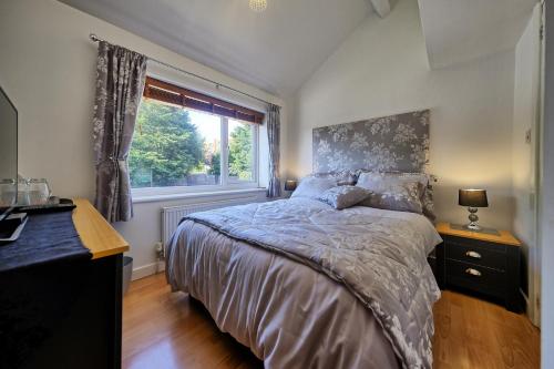 sypialnia z łóżkiem i oknem w obiekcie Upton Village Guest House w mieście Birkenhead