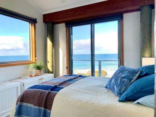 a bedroom with a bed with a view of the ocean at Surf Shack in Wye River