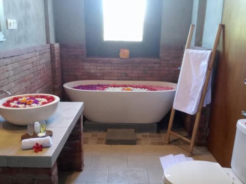 a bathroom with two large tubs and a toilet at Araya villa saba in Saba