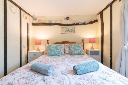 a bedroom with a bed with two pillows on it at Cobweb Cottage Studios in Spooner Row