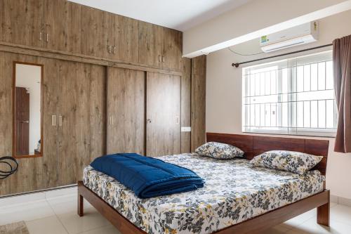 1 dormitorio con 1 cama con pared de madera en Pinnacle Serviced Apartments, en Bangalore