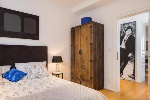 a bedroom with a bed and a wooden cabinet at Charlie Chaplin in Split