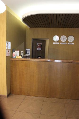 a lobby with a counter with two clocks on the wall at Kolobok in Luts'k