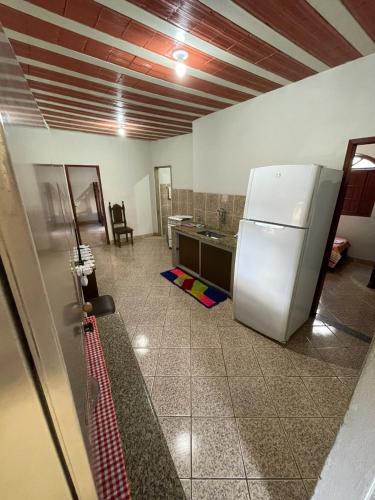 a kitchen with a white refrigerator in a room at Pousada Regina in Cachoeiro de Itapemirim