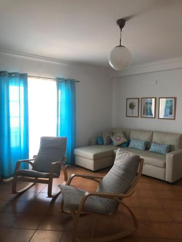 a living room with a couch and two chairs at PÉ NA AREIA by Stay in Alentejo in Vila Nova de Milfontes