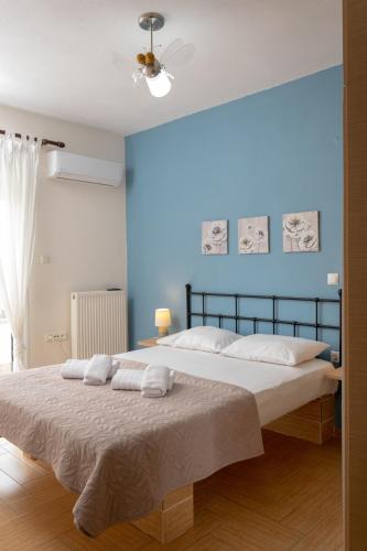 a bedroom with a bed with a blue wall at SeastheDayApartment in Nea Peramos