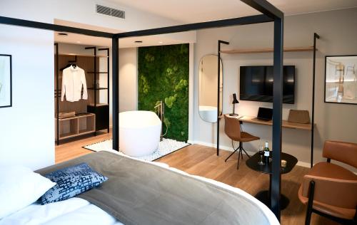 a bedroom with a bed and a room with a desk at Hotel Oasia Aarhus City in Aarhus