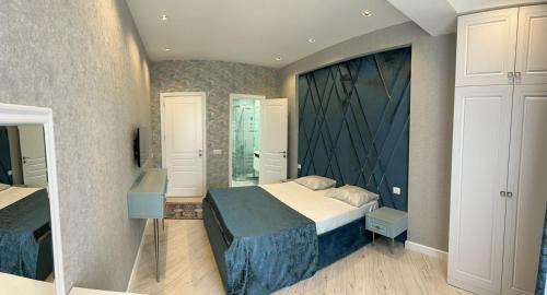 a bedroom with a large bed and a mirror at Seaside Luxury Apartment in Sumqayıt