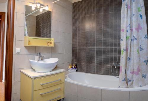 a bathroom with a sink and a tub and a shower at SeastheDayApartment in Nea Peramos