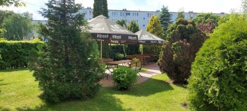 a gazebo with a picnic table in a garden at Hotel Wanda in Kętrzyn