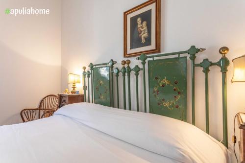 una camera con un letto con copriletto verde e bianco di Emma's Villa fronte mare con piscina a Torre Suda