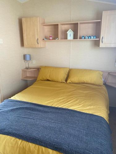 a large yellow bed in a room at Comfy 2 bed holiday caravan in Whitstable