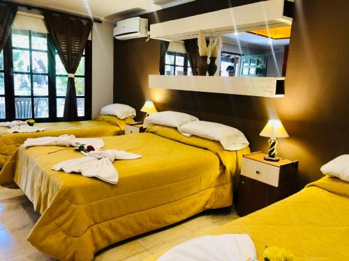 Habitación de hotel con 3 camas y toallas. en Hotel Villa Santa Maiani en Mar del Plata