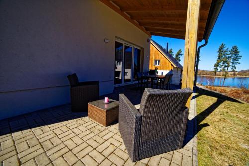 a patio with chairs and a table with a candle at Lipno - Lakeside Village - Větrník in Frymburk