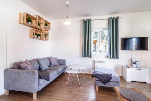 a living room with a couch and a table at Lipno - Lakeside Village - Větrník in Frymburk