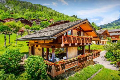 a house with a wrap around porch and a balcony at Chalet Musini - OVO Network in Le Grand-Bornand