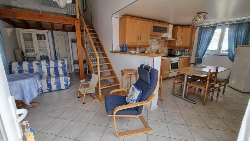 a living room with a staircase and a kitchen with a table at Les Mésanges in Royan