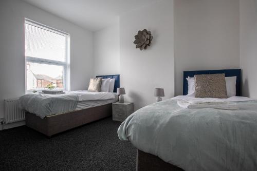 1 Schlafzimmer mit 2 Betten und einem Fenster in der Unterkunft Central Location & Spacious Family & Contractors & Free Parking in Derby