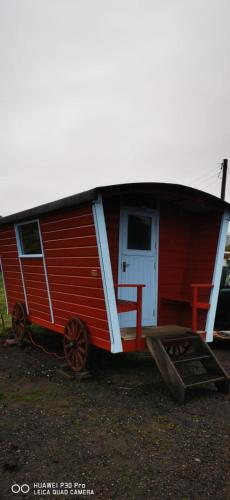 a red house with a roof on top of it at Gypsy hut in Newtonmore