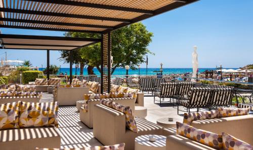 a restaurant with chairs and the beach in the background at Hotel Serrano Palace in Cala Ratjada