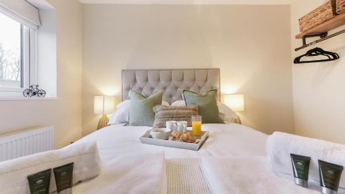a bedroom with a bed with a tray with candles and two glasses at Hareshaw House in Bellingham