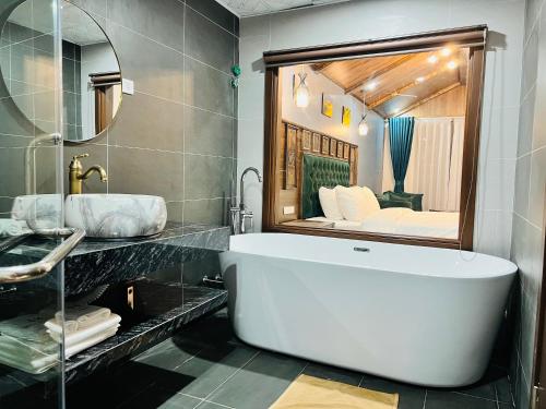 a bathroom with a large tub and a large mirror at Sapa Grand Hills Hotel Apartments in Sa Pa