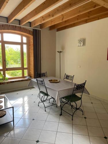 une salle à manger avec une table et des chaises dans l'établissement Le Moulin de Cherré gîte vert, à Aubigné-Racan