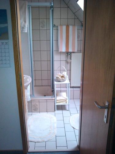 a small bathroom with a shower and a sink at Sonnendeich in Norddeich