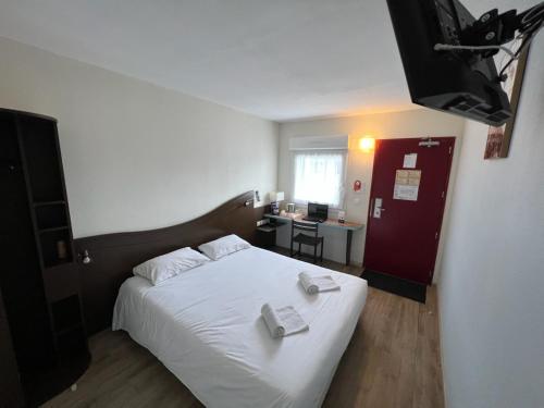 1 dormitorio con 1 cama con 2 toallas en Contact Hôtel Fontenay le Comte, en Fontenay-le-Comte