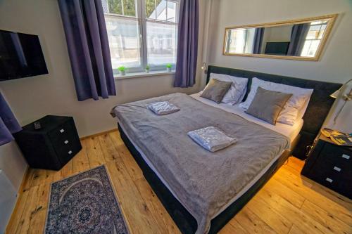 a bedroom with a bed with two towels on it at Lipno - Lakeside Village - Větrník in Frymburk
