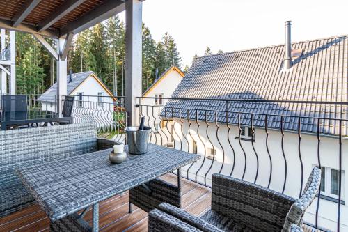 a patio with a table and chairs on a balcony at Lipno - Lakeside Village - Větrník in Frymburk