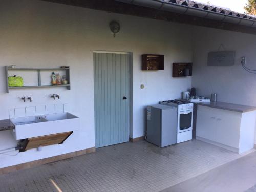 eine Küche mit einer Spüle und einem Herd in der Unterkunft Inviting 2-Bed Cabin in DOMFRONT EN POIRAIE in Perrou