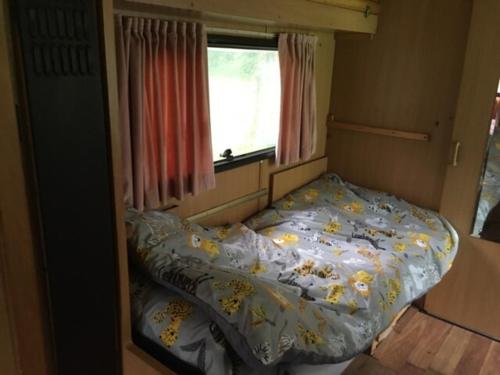 Cama en habitación pequeña con ventana en Inviting 2-Bed Cabin in DOMFRONT EN POIRAIE, en Perrou