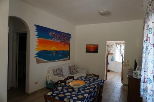een kamer met een tafel, een bank en een schilderij bij Bivilla Incalzi in Villanova di Ostuni