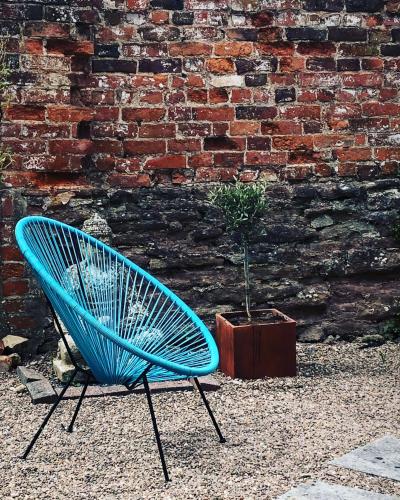 a blue chair sitting in front of a brick wall at 6 Wye Valley Chambers, Ross-on-Wye in Ross on Wye