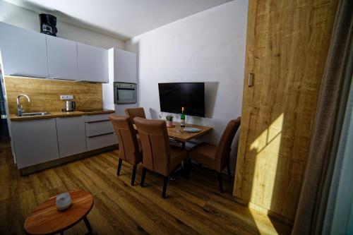 a kitchen with a table and chairs in a room at Lipno - Lakeside Village - Větrník in Frymburk