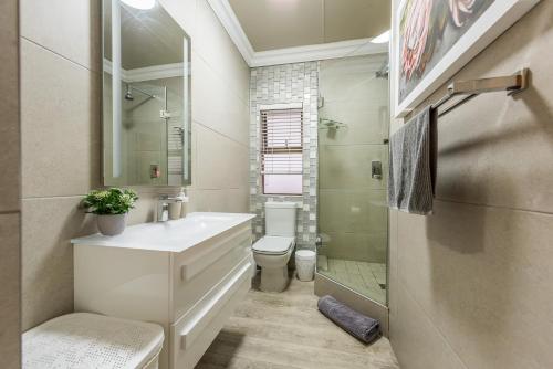 a white bathroom with a sink and a toilet at Beacon Wharf , George Hay 6 Seafront Accommodation in Mossel Bay