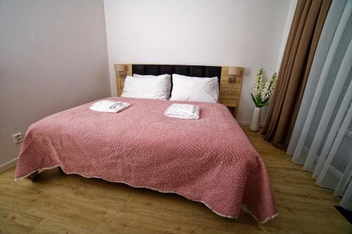 a bedroom with a bed with a pink blanket at Lipno - Lakeside Village - Větrník in Frymburk